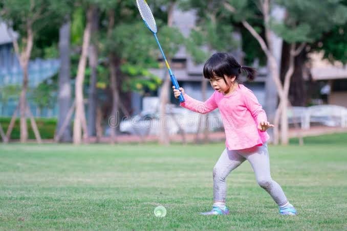Child playing badminton outdoors